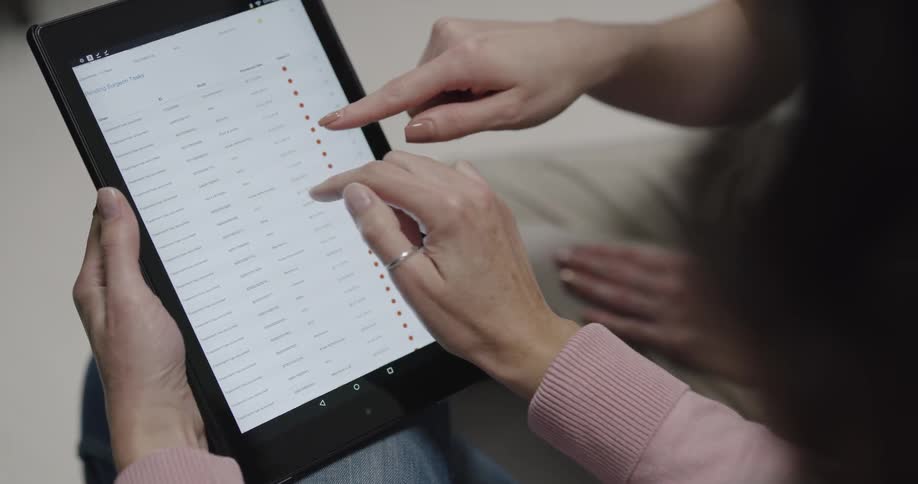 Two woman look through options displayed on a tablet