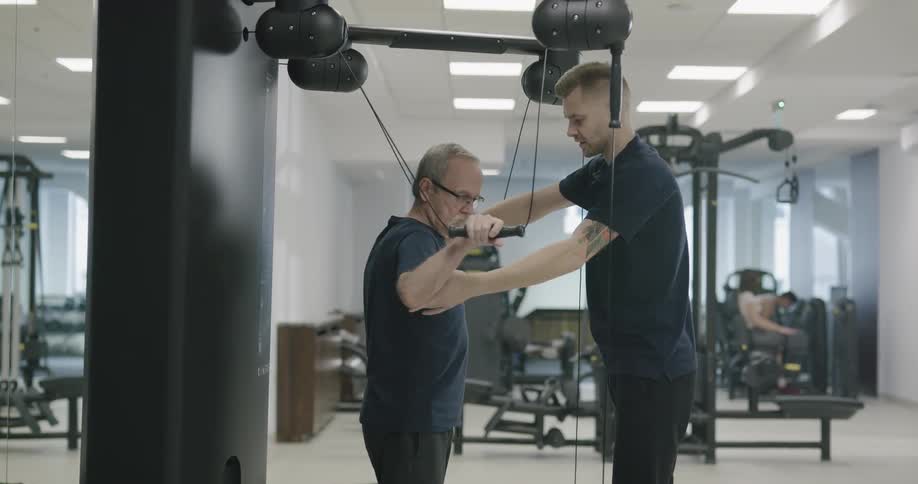 A physical therapist helps a patient with exercise equipment