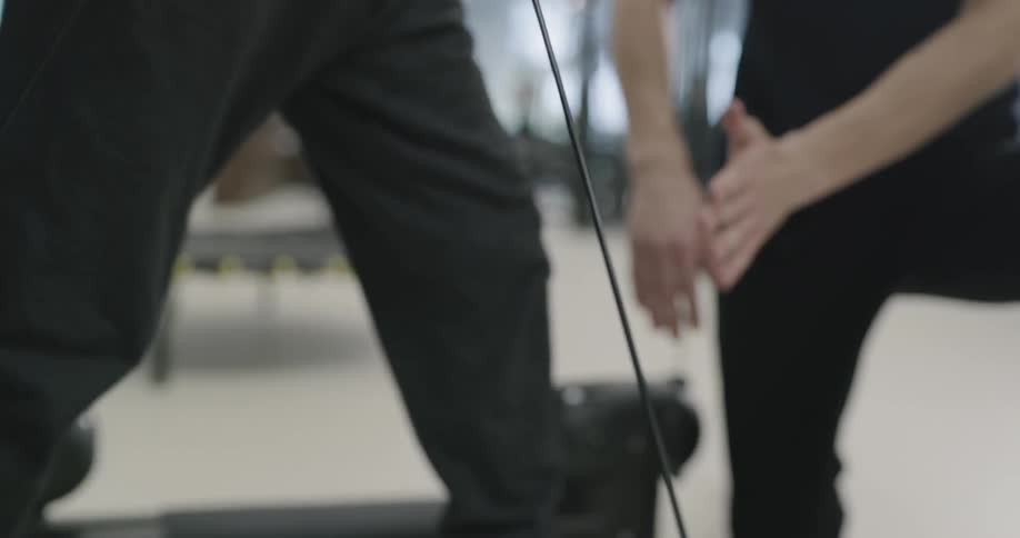 A man doing resistance training with the guidance of a personal trainer