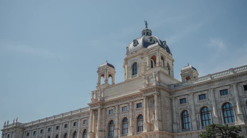 A flag blows in the wind in front of a large ornate building