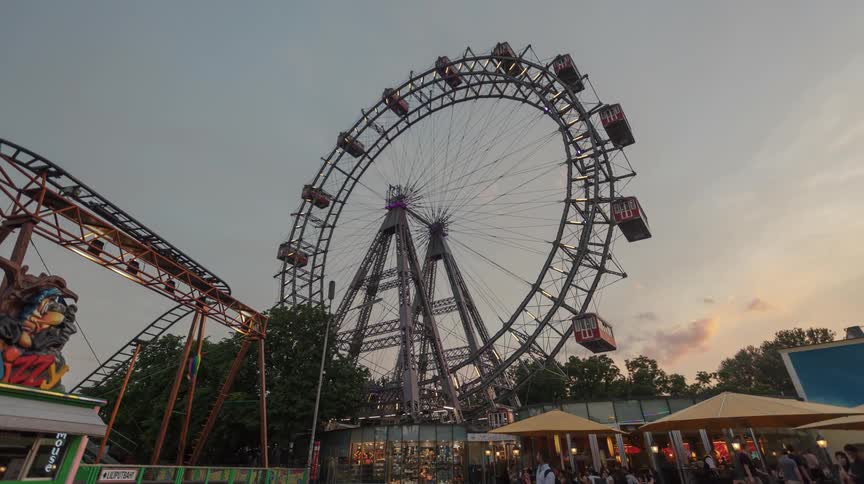 A ferris wheel in a fairground in the evening