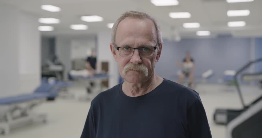 Man stands in large room with stretchers