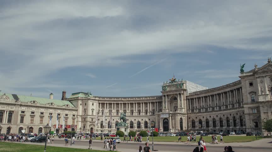 People traveling around a large public building during the day