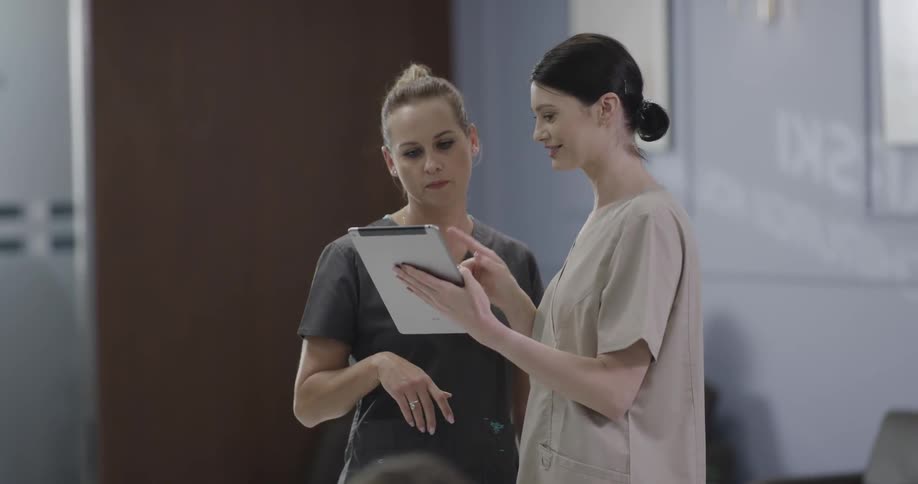 Nurses use tablet and talk in the hospital during daylight