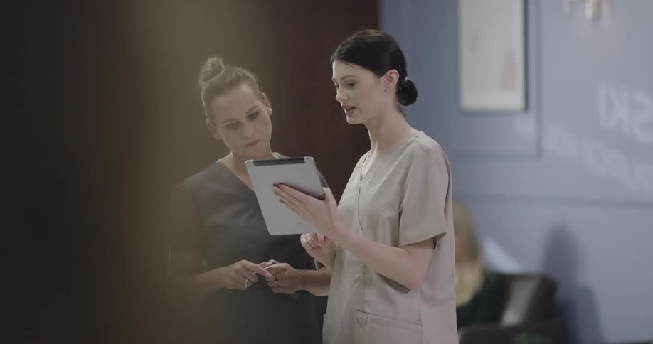 Two female nurses look over a chart together and discuss it