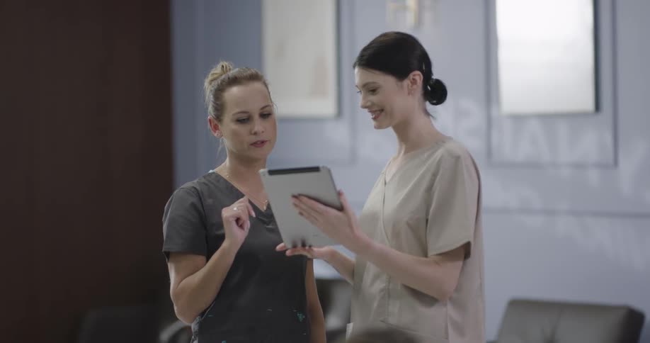 Two nurses checking tablet on waiting room