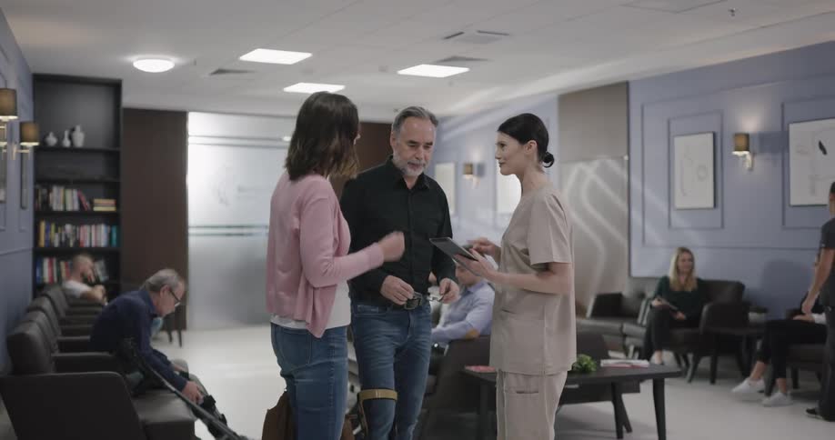People walk through a waiting room and then talk to a nurse