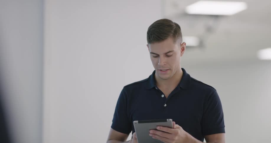 A young man talks and types on a tablet