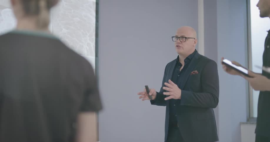 Man stands near large screen and lectures