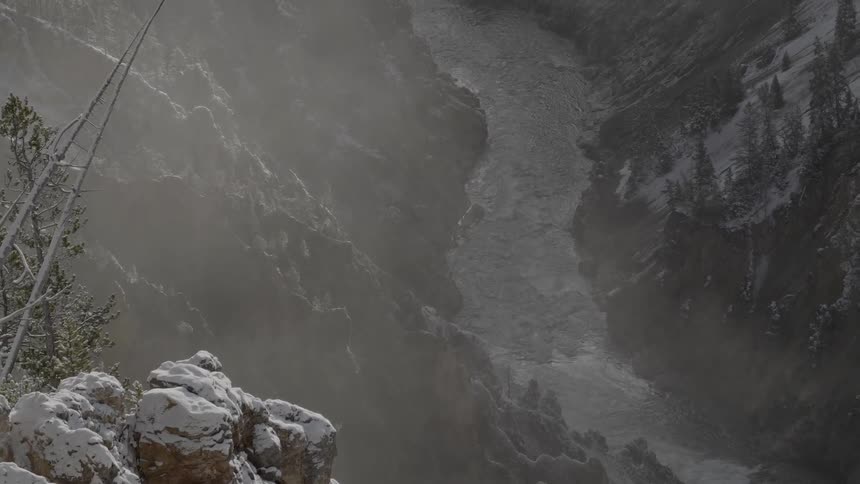 A frozen river through a valley of a snowy mountain range