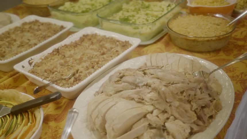Potluck buffet spread on long tablecloth covered table