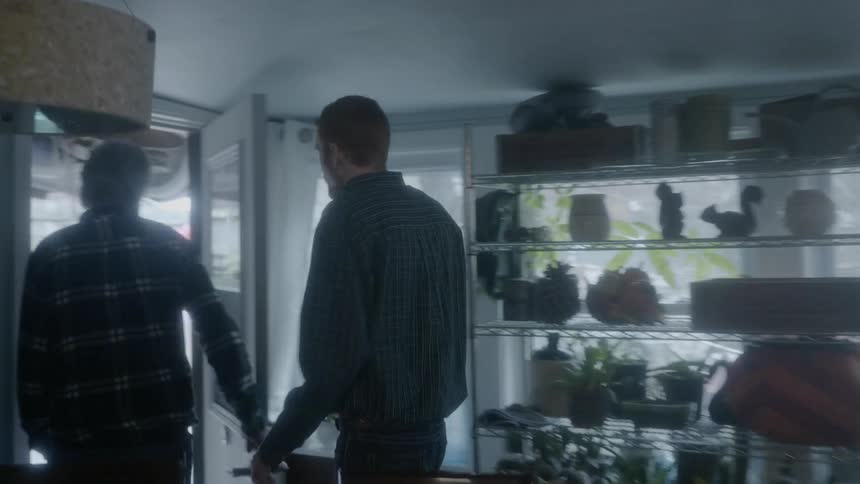A tall man walking through a house and exiting through the door along with other men