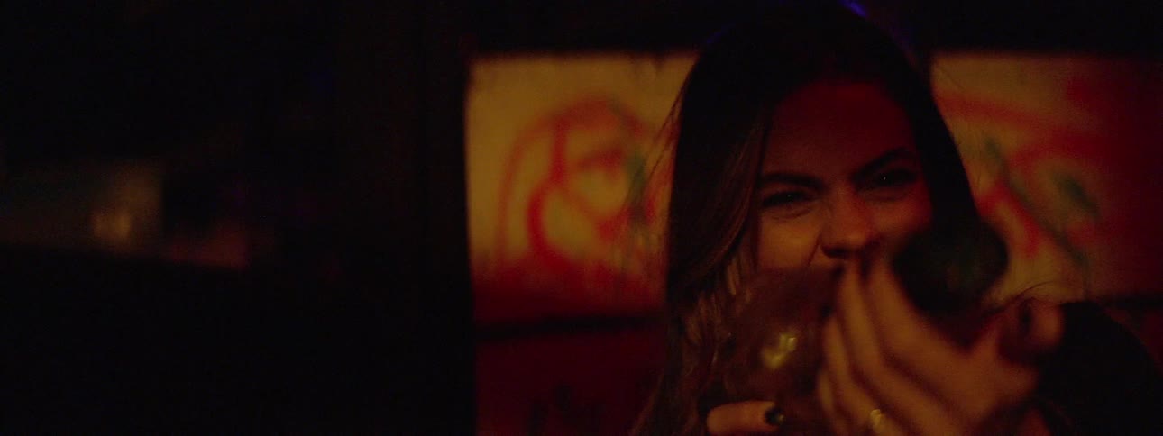 A woman laughs as she points a green glowing toy gun