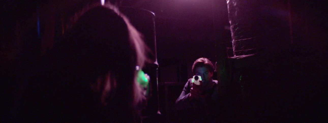 Man and woman playing laser gun at the dark