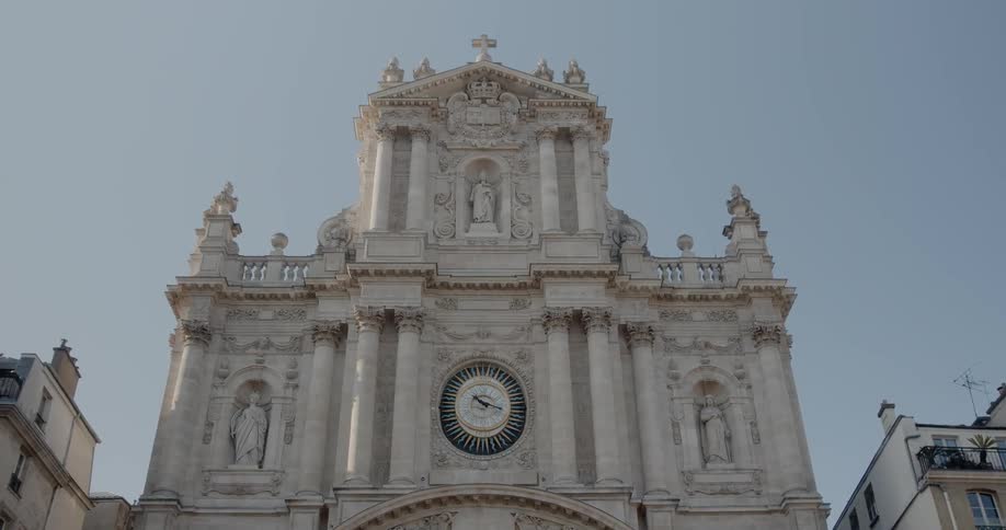 A church with classical architecture is decorated with numerous pillars and statues of saints
