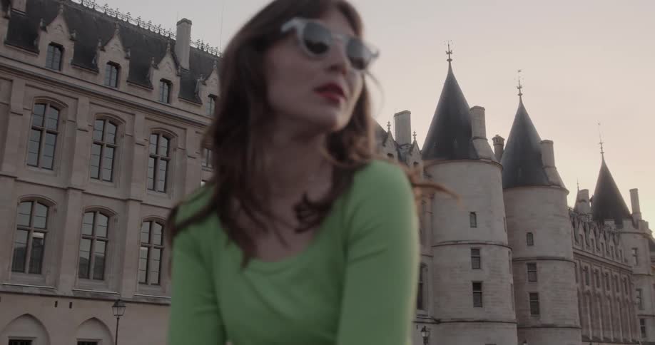 Woman with glasses and green shirt looking at the surrounding