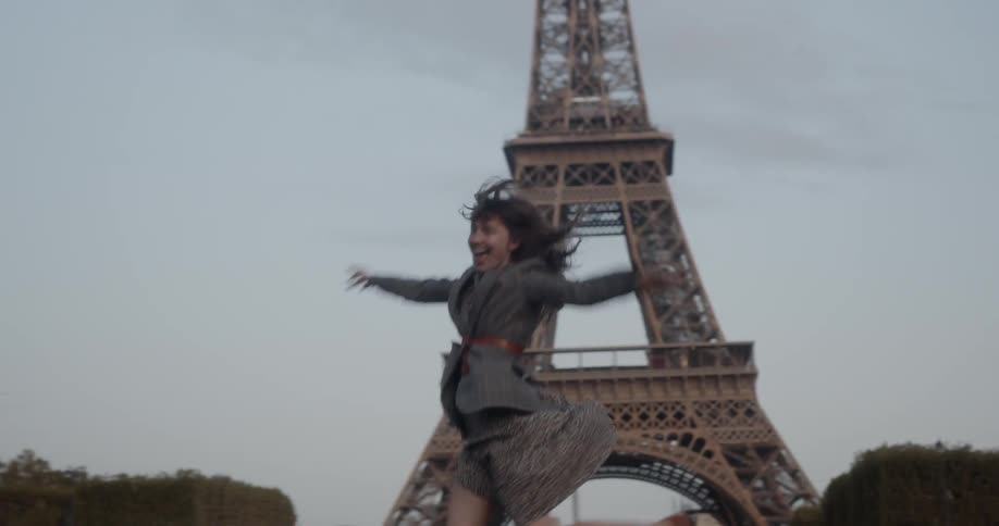 Woman runs and leaps in front of eiffel tower