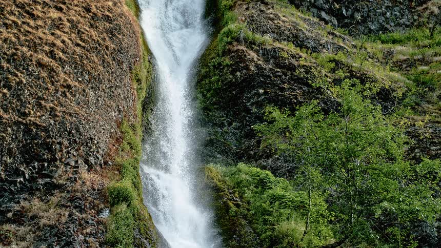 A waterfall crashes down the side of a mountain