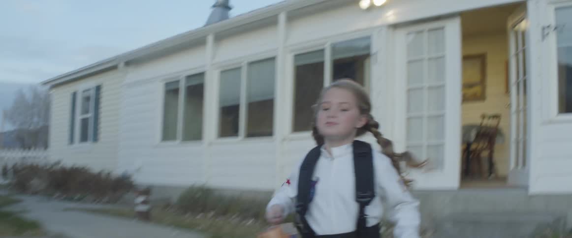 A girl leaves the house running in the yard