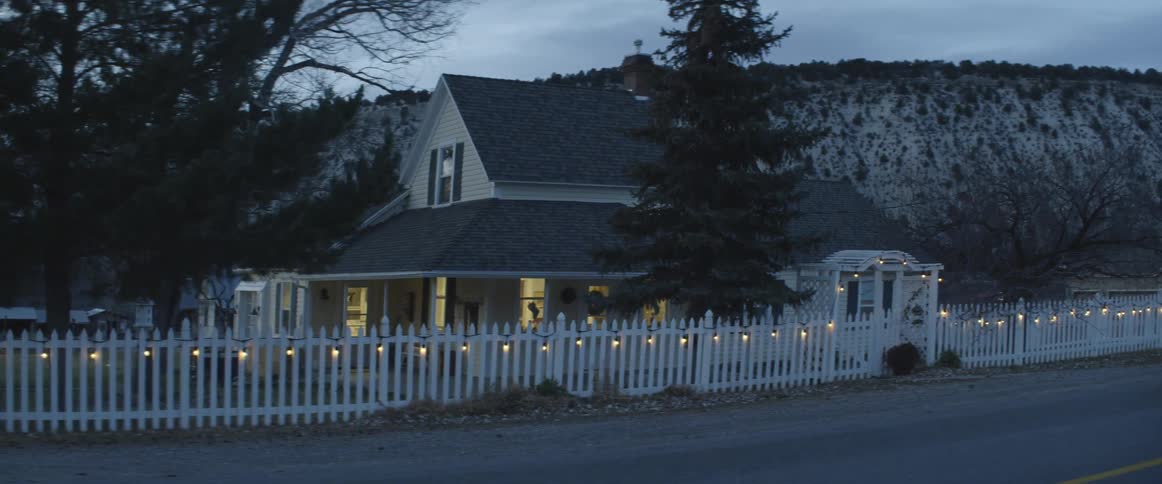 House sits surrounded by a white picket fence