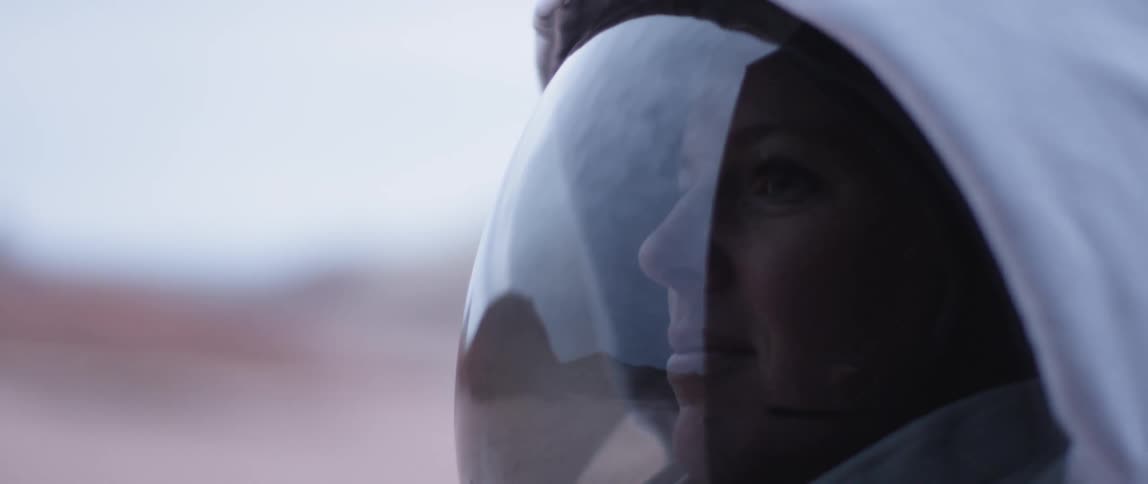 A woman smiles in an astronauts helmet