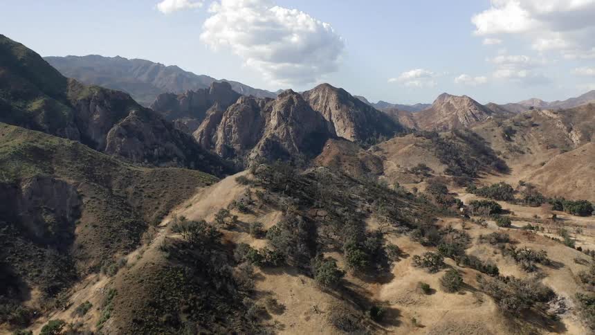 Mountain peaks with dried brush dirt and sand in the valleys