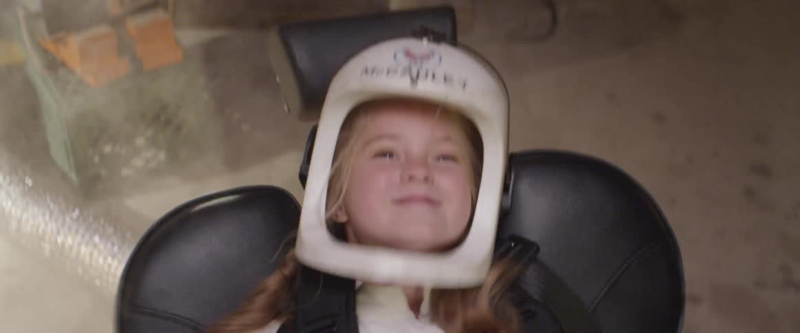Girl plays at being an astronaut while wearing costume