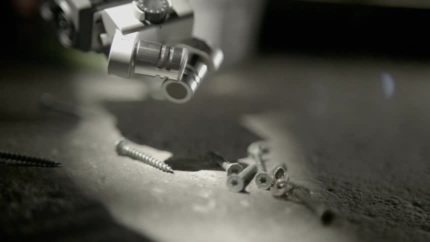 A machine throwing out some screw to the ground