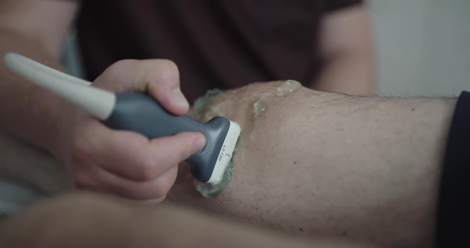 A gel being rubbed on a knee with a medical device