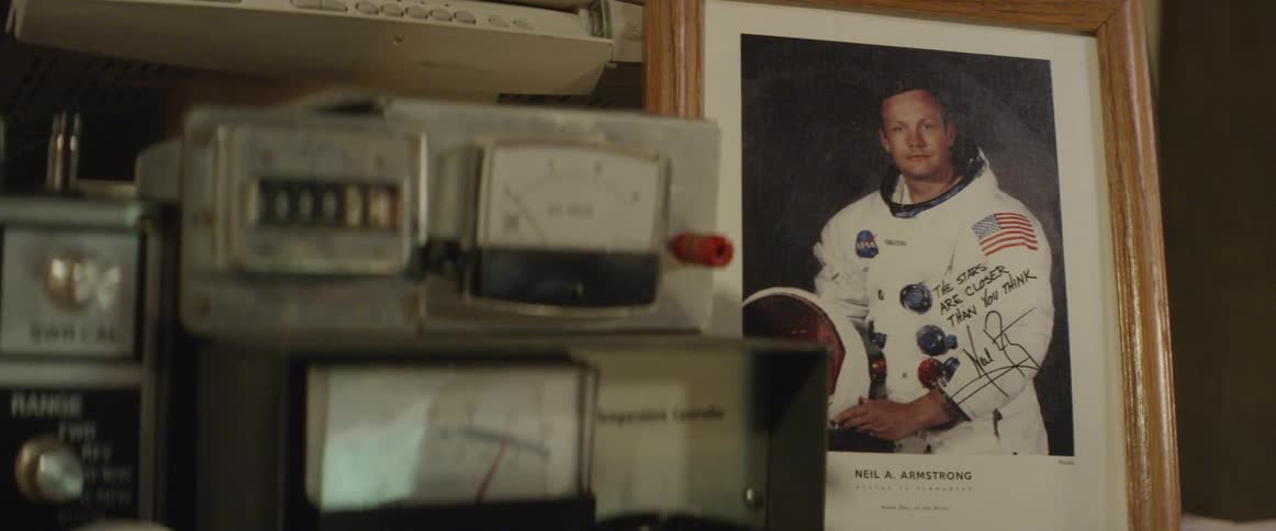 Vintage space radio control next to framed photo of neil armstrong