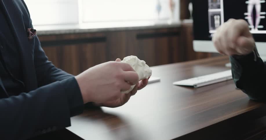 A person shows another person a model of bones