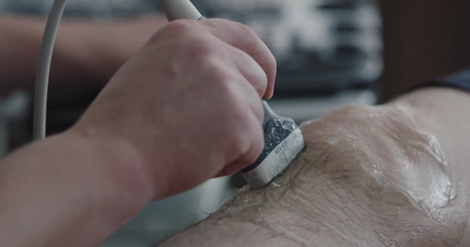 A man is getting an ultrasound of his knee