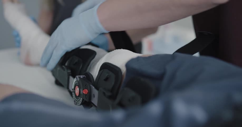 Doctor removing brace from the patient leg