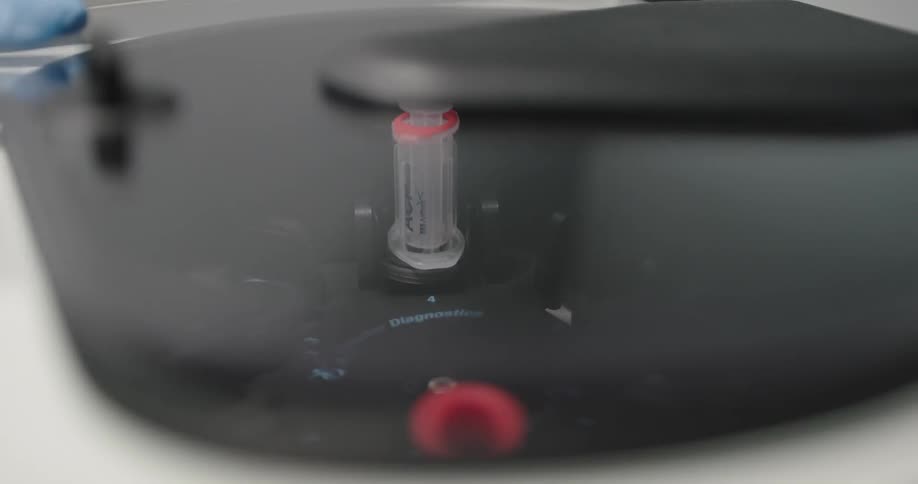 A person puts a needle into a diagnostic machine