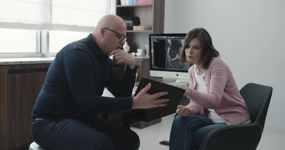 A man talks with a woman in a doctors office