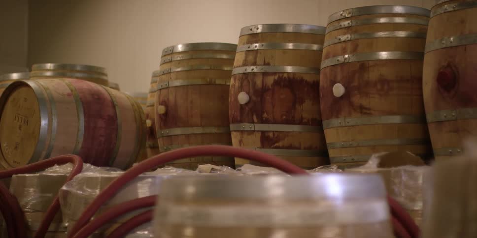 Barrels are stacked against a wall in a warehouse