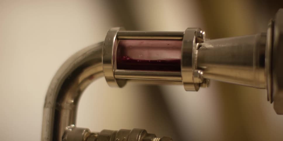 A machine is processing berries into a juice