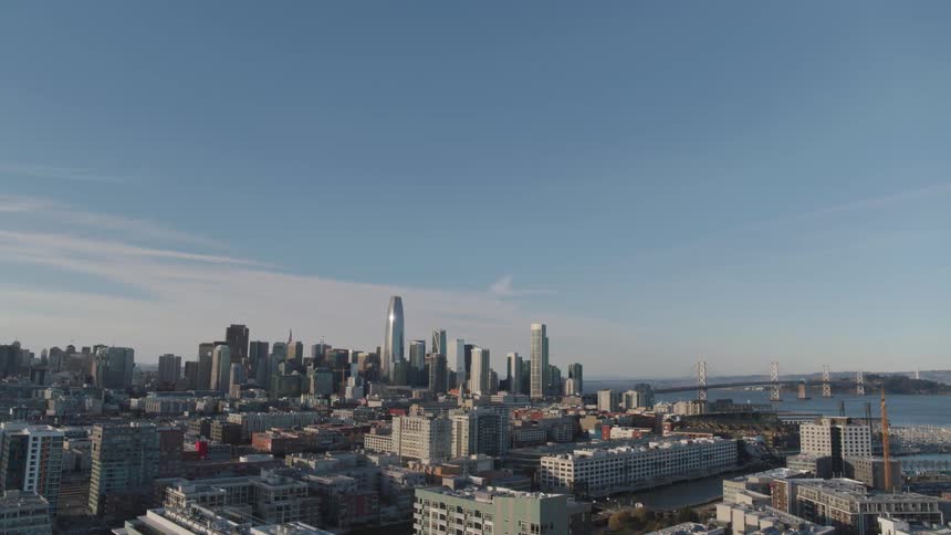 A skyscraper towers above the skyline of a city near the ocean