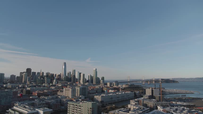 Skyscrapers and buildings in a coastal city skyline under a blue sky