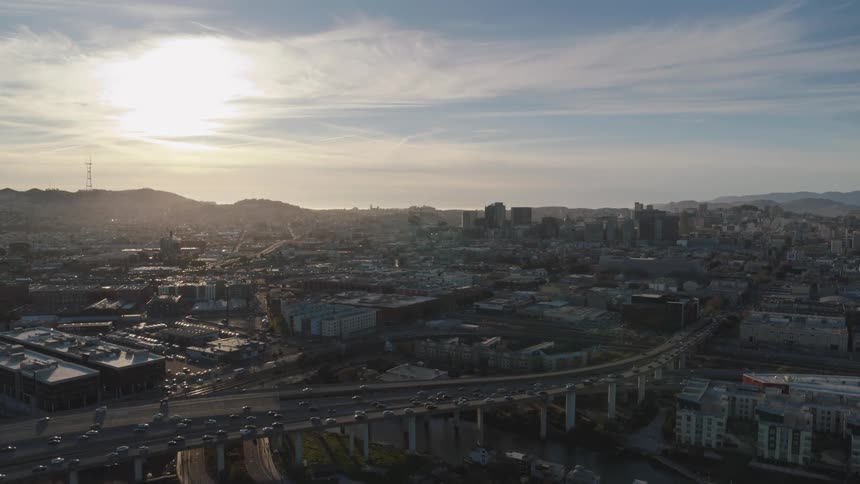 An aerial view of cars driving on a highway overpass in a city