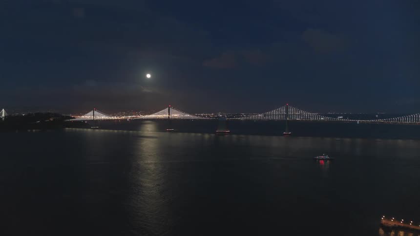 The bridge is brightly lit in the distance