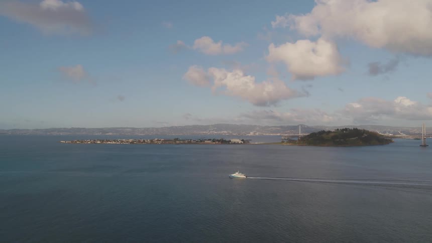A boat motors past an island in the ocean