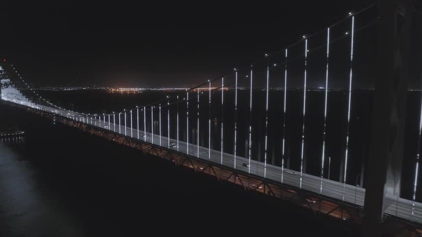 A suspension bridge is illuminated at night