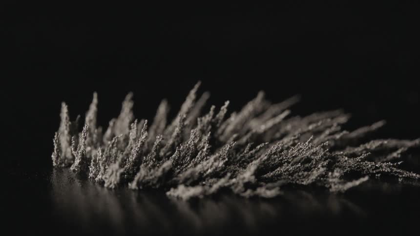 Metal filings are manipulated by magnetic field