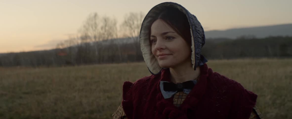 Woman in a bonnet watches something in the distance