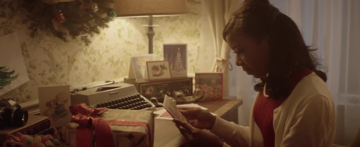 A woman reads a card at a desk