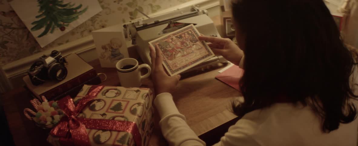 A person is sitting at a desk looking at a card