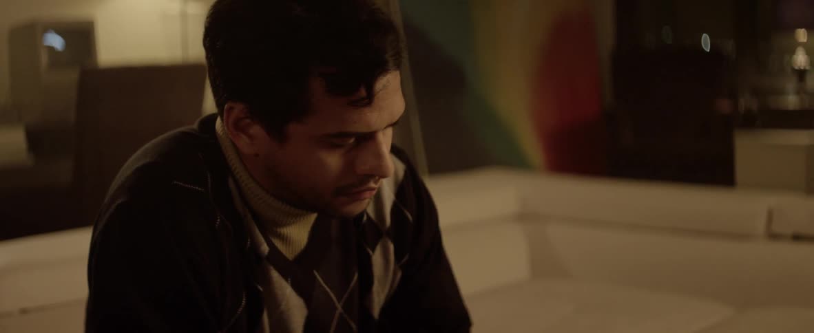 A man sitting on a sofa with a serious expression on his face