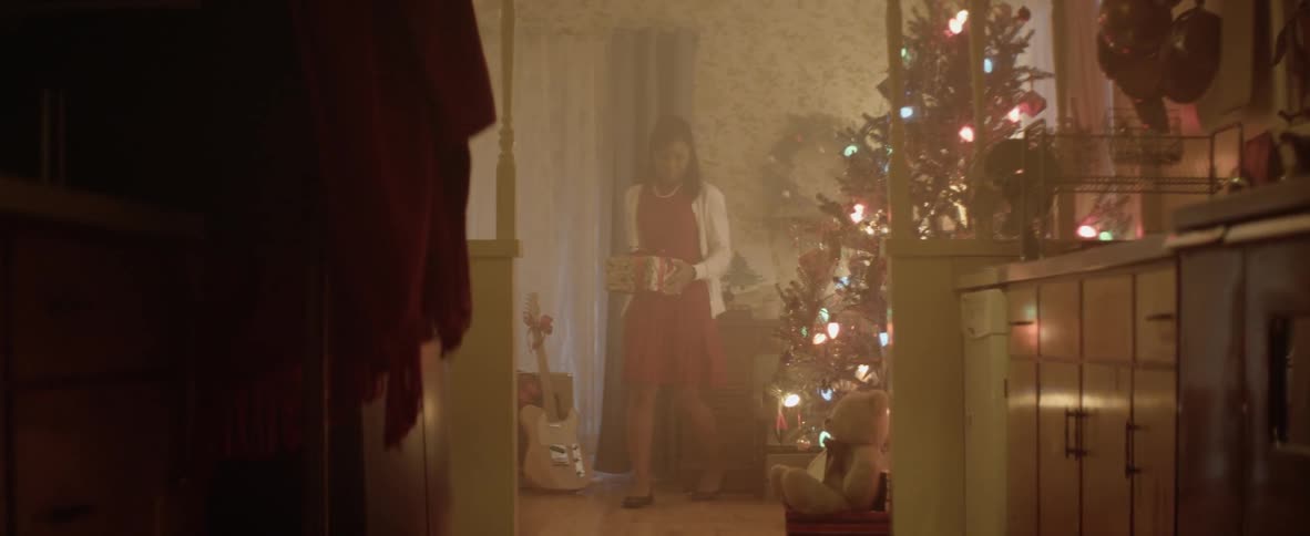 Mother carefully placing the christmas gift on the tree