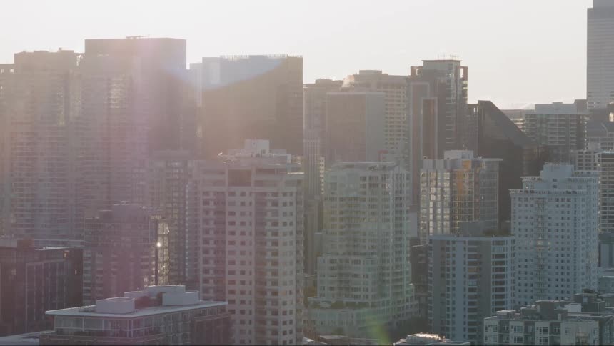 The sun shines behind the buildings in the city